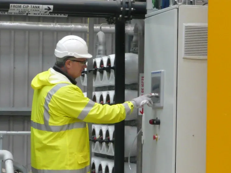 A plant operator at a reverse osmosis control panel