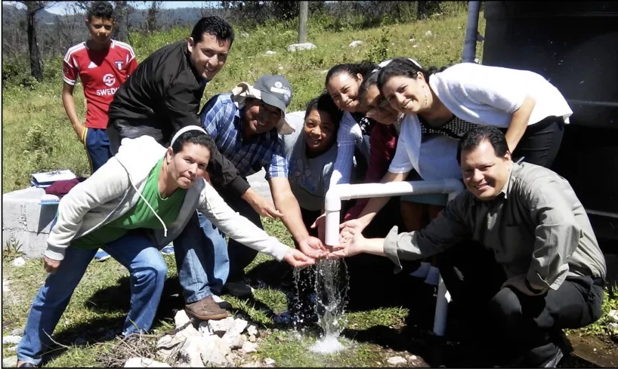 The team celebrating the first water delivered on site